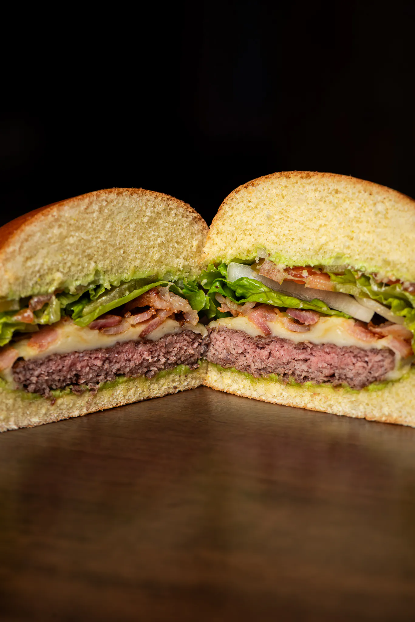 Brouss Bacon Salada cortado ao meio: carne bovina ao ponto, queijo, bacon, cebola, tomate e alface.